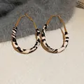 Close-up of golden teardrop earrings with retro leopard print patterns on a plush surface - 37# Silver Pin - Brown - Oval (Leopard Patchwork Metal)