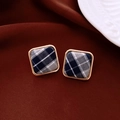 Detailed view of square stud earrings with blue plaid fabric and gold metal frames - Light Blue