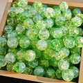 Macro detail of green and yellow cracked glass beads for DIY jewelry making on wood tray - M57# Bean Green [10MM Water Dyed]