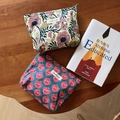 Detalle de dos neceseres de algodón con estampado indio vintage sobre una mesa de madera - Flores Rojas sobre Fondo Azul Oscuro