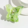 Close-up of light green acetate butterfly hair claw clip with marble texture and gold spring - Green Smudge