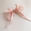 Dettaglio ravvicinato di un fiocco per capelli in pizzo rosa con paillettes e perle - Fiocco in fettuccia con nastri (Clip)