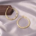Chic twisted golden hoop earrings in large size on premium satin fabric background - Twisted Hoop / E-009---Gold