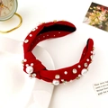 Close-up of a red fabric headband adorned with white pearls and sparkling rhinestones - Red