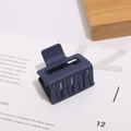Detail of matte dark blue rectangular hair claw clip with hollow geometric design - 5cm / Blue