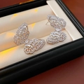 Detailed macro view of butterfly stud earrings with sparkling cubic zirconia in jewelry box - Silver