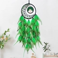 Green dream catcher with tree of life design and vibrant feathers on white wall - Green