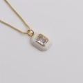 Macro detail van de vergulde ketting met een witte geometrische kristallen hanger - Wit