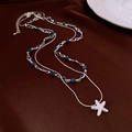 Dettaglio della collana a doppio strato con ciondolo a stella marina e perle blu su velluto - Argento