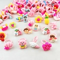 Détail montrant un assortiment de bagues colorées en plastique pour fillettes - Bagues Style Dessin Animé Couleur Unie pour Filles