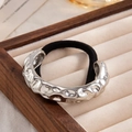 Chic silver hammered metal ponytail holder with black elastic band on velvet tray - Silver - Irregular Texture