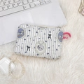Detail of quilted cartoon makeup bag with carousel print on soft plush background - Badge Bear