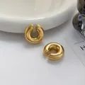 Orecchini a clip a cerchio C dorati lucidi su un vassoio bianco minimalista - 24K / Oro (1 pezzo)