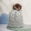 Detailed view of grey cable knit texture and soft faux fur pompom on winter hat - One Size / Light Gray