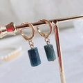 Golden hoop earrings featuring cylindrical deep blue natural stone pendants with textures - Blue Apatite