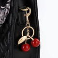 Porte-clés cerise rouge avec feuille dorée sur sac en cuir matelassé et foulard soie - Rouge