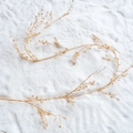 Elegant gold bridal hair vine with sparkling crystals on white snow-textured background - 120cm Gold Decorative Rattan