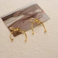 Macro detail van vergulde strikoorbellen met slangenketting textuur en hanger - Goud (DEK409)