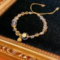 Dettaglio del bracciale con perline di citrino e ciondolo dorato su velluto nero - Bracciale di Perline in Citrino e Cristallo Bianco (Con Confezione Regalo)
