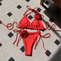Vibrant red bikini set with 3D rose decorations and adjustable side ties on flatlay - Red