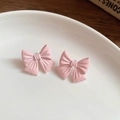 Macro shot of sweet pink bow stud earrings on a white ceramic plate with wood background - 12# Pink Enamel Bow Stud Earrings (Steel Pin)