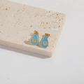Macro view of gold-plated avocado stud earrings with blue enamel and small white zircons - Blue