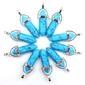 Macro-opname van blauwe turkoois kristallen hangers met zilveren metalen kapjes op witte basis - Turkoois