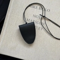 Close-up of black leather croissant pendant key sleeve with fine stitching on book - 1# Necklace-Black-Arc