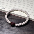 Handcrafted Bodhi root bracelet featuring cream beads and a dark red carved cat paw charm - Star Moon Bracelet (Sandalwood Carved)