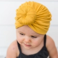 Detail of soft mustard yellow knit baby headband with a twill print bow on an infant - Yellow