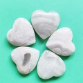 Polished white and grey heart-shaped agate stones with natural stripes on green fabric - Agate