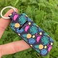 Lipstick holder keychain with tropical flamingo and pineapple print being held by hand - Pineapple Flamingo