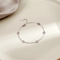 Detailopname van een zilveren geometrische armband op een keramisch dienblad met schaduw - Zilveren Tandwiel(S228)