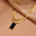 Collar de doble capa en acero dorado con colgante cuadrado negro sobre fondo de seda - Oro Concha Negra (D111)