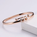 Dettaglio del bracciale in oro rosa con tre anelli scorrevoli diamantati su pietra bianca - Oro rosa