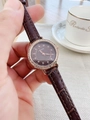 Detailed view of women's vintage watch featuring rose gold rhinestone bezel and brown leather strap - Coffee