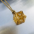 Golden mesh cage pendant necklace featuring an amber twenty-sided D20 gaming dice - Gold Cage with Yellow Dice