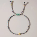 Handmade woven cross bracelet with adjustable purple, blue, and pink ropes and gold charm - Blue Purple Pink Gold Cross