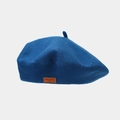 Close-up of a navy wool beret featuring a brown leather patch with LOVE STYLE text - Aqua