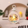 Close-up of white Christmas LED lantern featuring a snowman scene on a warm indoor table - Round White Snowman