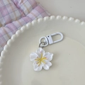 Detail von Kirschblüten-Schlüsselanhänger mit weißen Blütenblättern auf einem Keramikteller - Cremeweiß