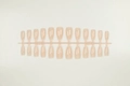 Detailed view of almond shaped nude pink press-on nail tips on professional salon display - Jelly Natural Nude (SD-20)