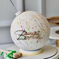 Detail of white birthday cake ball with colorful speckles, gold topper and small wooden mallet - Design No.2 / Gold