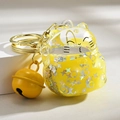 Detail of yellow Maneki Neko keychain featuring moving liquid glitter and a golden bell - Lucky Cat Quicksand + Bell / Lemon Yellow