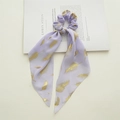 Dettaglio dell'elastico in chiffon lavanda con piume dorate e nastri lunghi - Nastro di piume viola