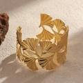 Golden ginkgo leaf open cuff bracelet with intricate cutout design on a textured stone - Gold Ginkgo Leaf
