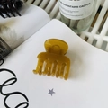 Nahaufnahme der bernsteinfarbenen Haarklammer auf einer Buchseite mit natürlichem Licht - Herbstgelb (Mittel 4,8 cm)