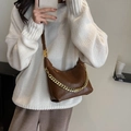 Brown quilted leather shoulder bag with gold chain strap shown on model in white sweater - Brown