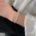Detailed close-up of a minimalist white pearl bracelet worn on a woman's wrist - Ultra-Fine White Pearl (MY31272)