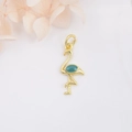 Macro detail of a 18k gold-plated flamingo pendant with blue enamel and floral accents - Teal